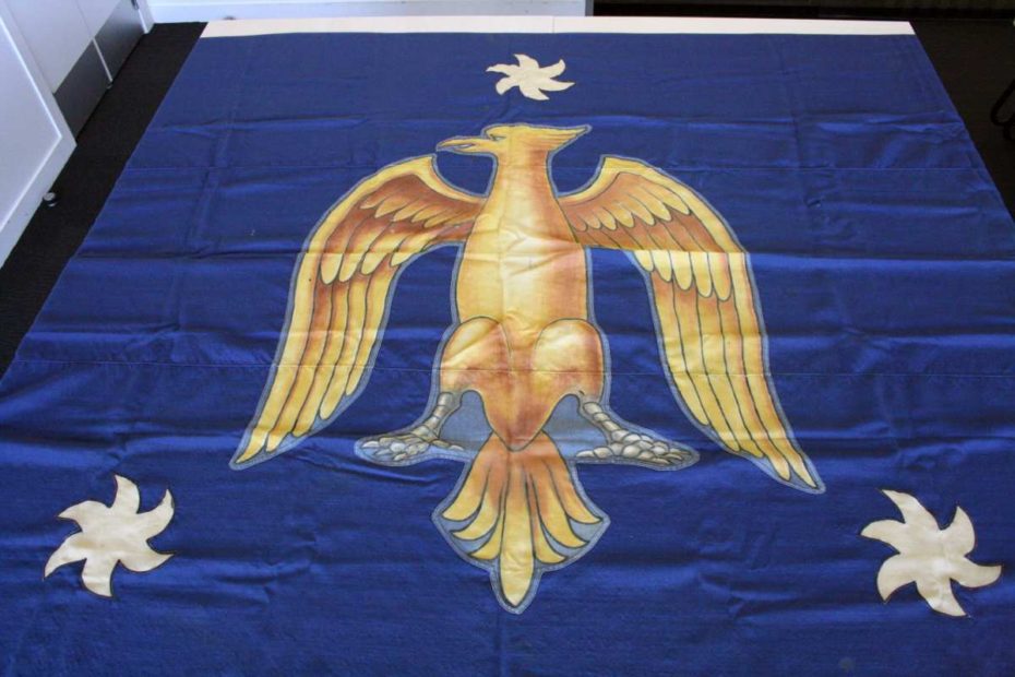 Blue flag with the St John's College coat of arms on the top in gold.