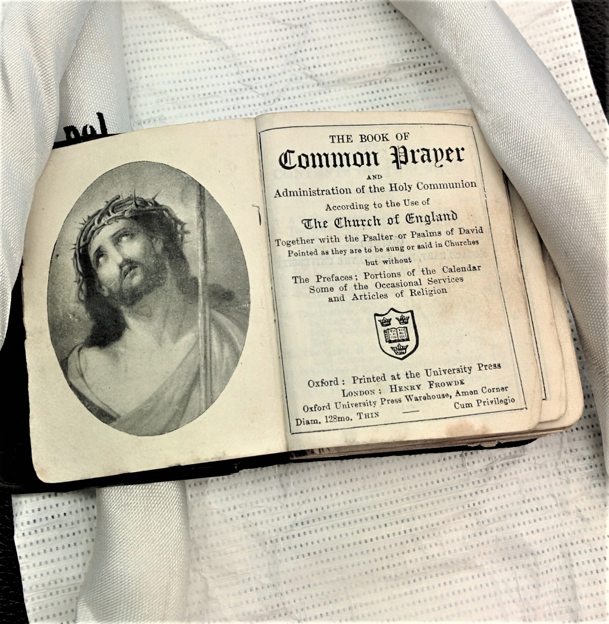 The Book of Common Prayer, open to the front page, lying on archival acid-free paper. Silver Book of Common Prayer at the Kinder Library.