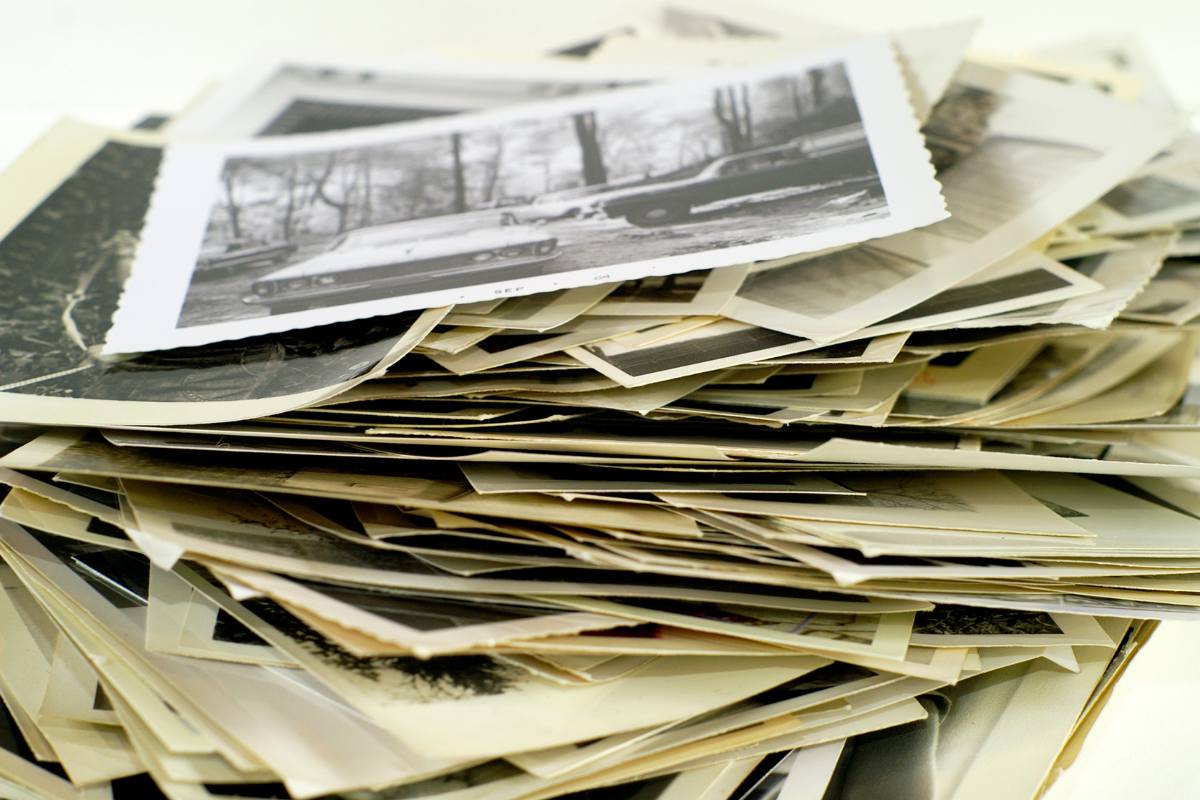 Close up stack of old photographs on a table.