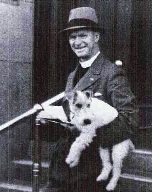 Black and white photo of Reverend Vickery holding a small dog